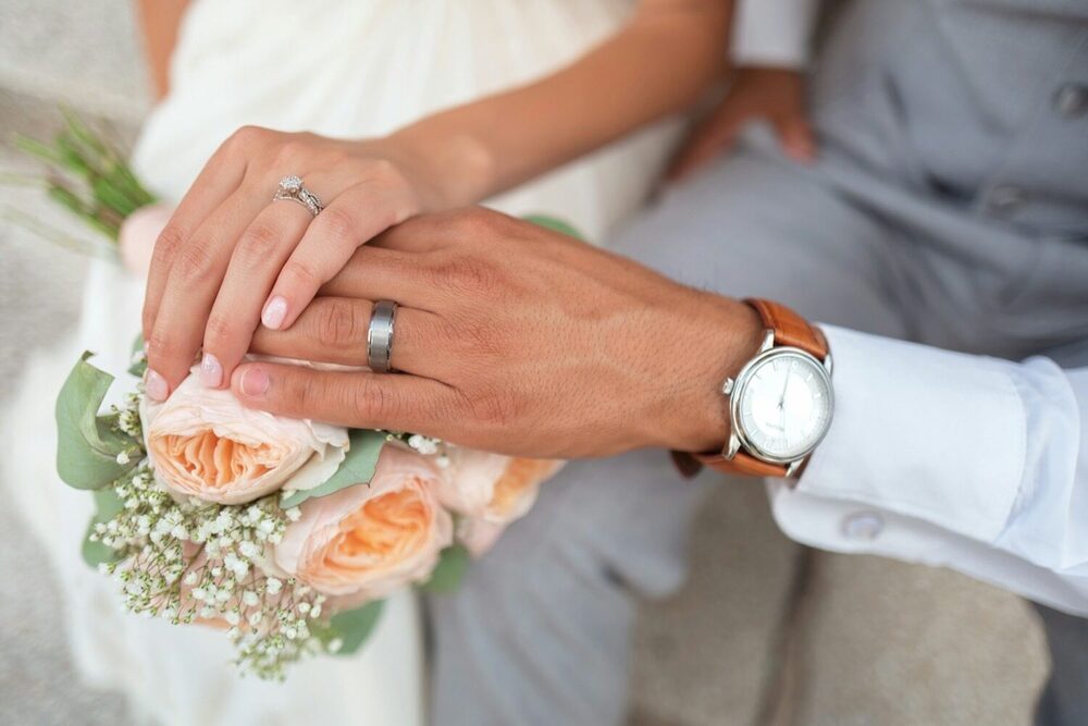 Đôi bàn tay đan vào nhau, khoe nhẫn cưới